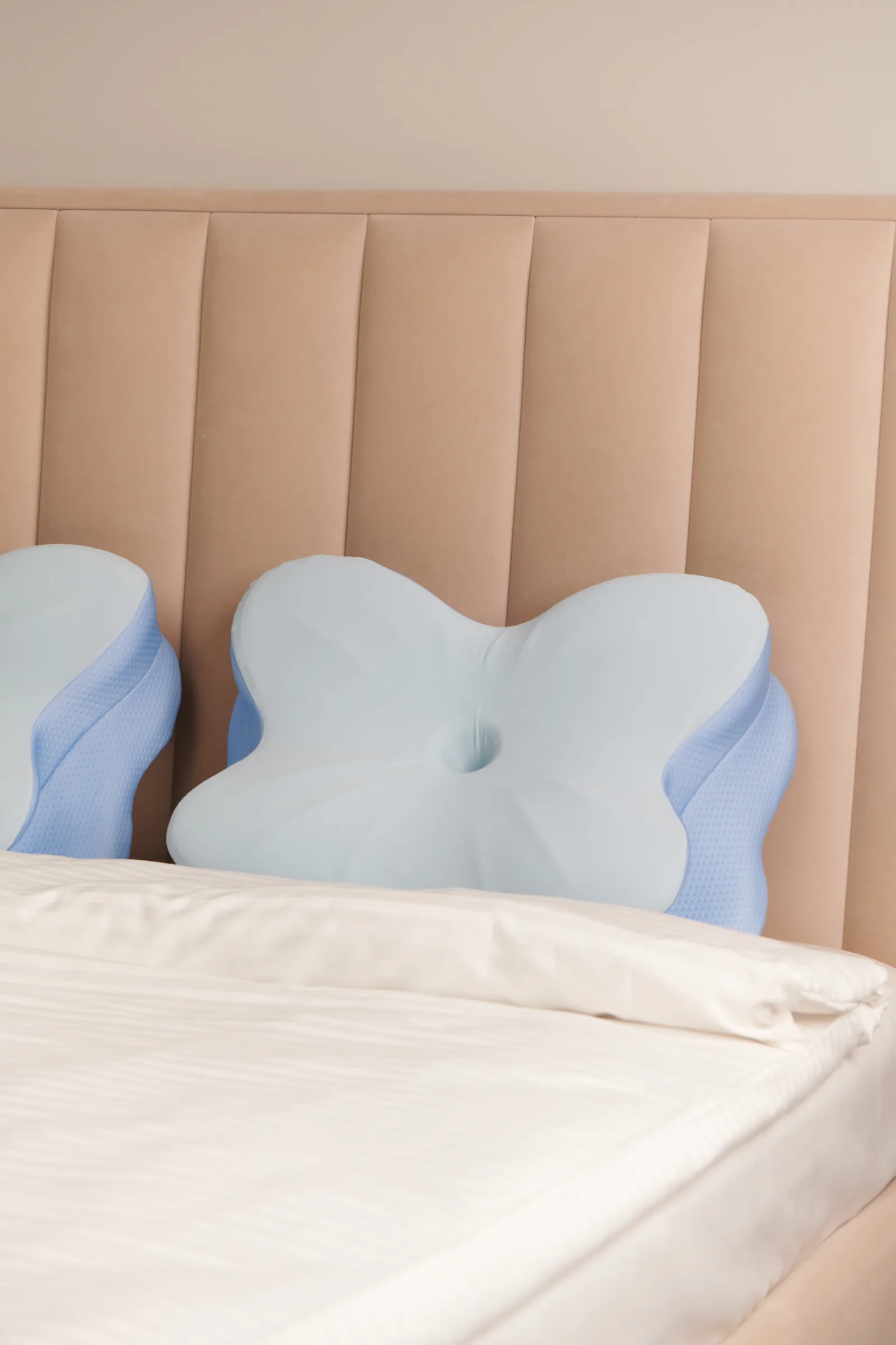 Contoured memory foam pillow placed on a neatly made bed