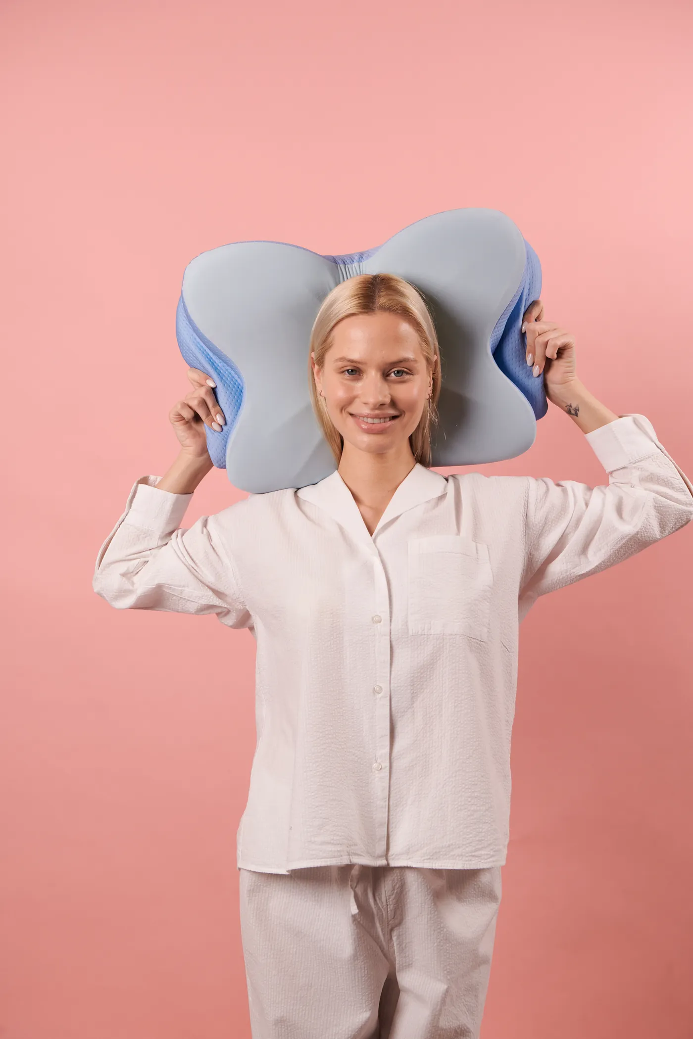 Person demonstrating a contoured memory foam pillow
